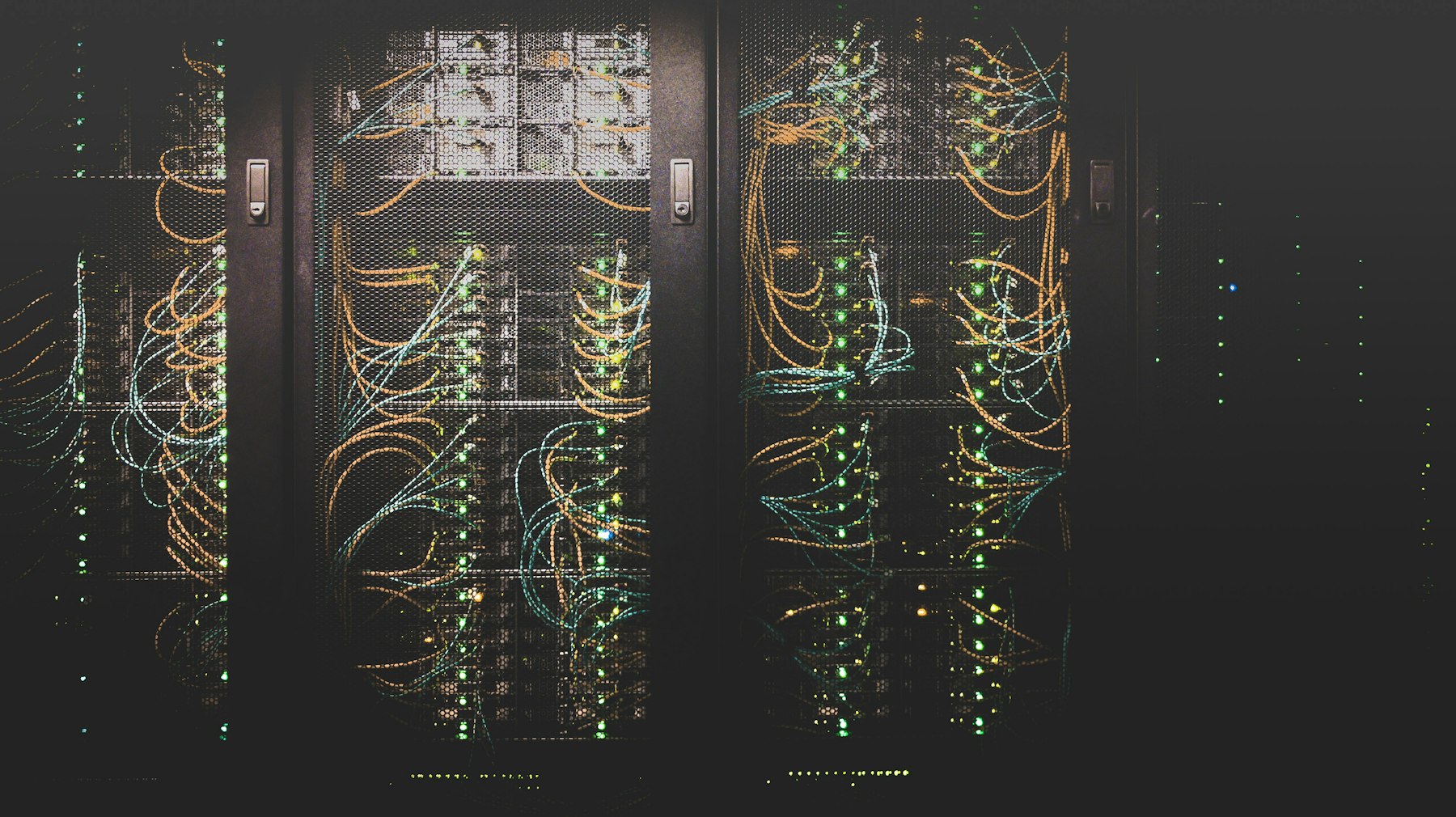 Server racks with orange and teal network cables, representing integration between procurement and finance systems